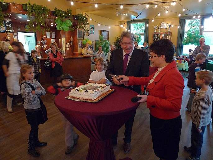 ... en opent de droomfair door een taart aan te snijden - droomboom-directeur edith rabbe kijkt toe en helpt een handje